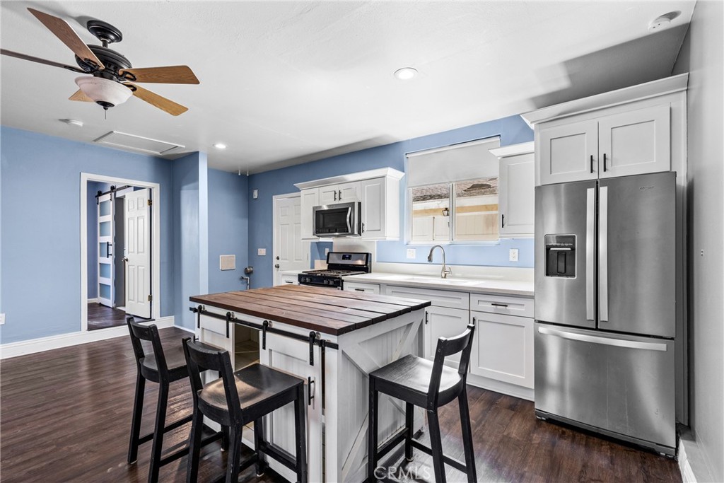 19403 Welby Way Reseda, CA 91335 - Photo 3 of 16 a kitchen with a table chairs refrigerator and cabinets