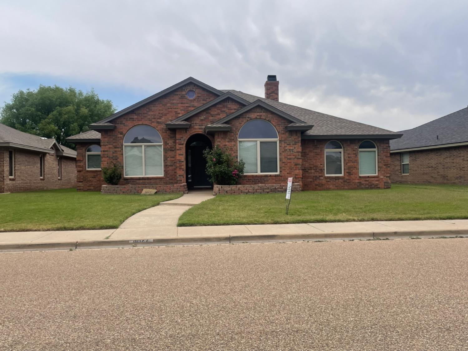 6027 100th Street Lubbock, TX 79424 - Photo 1 of 11 a front view of a house with a yard and garage