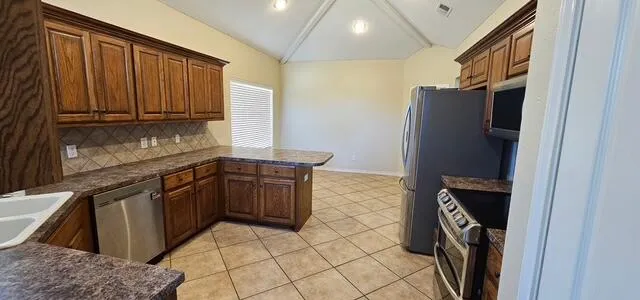a kitchen with stainless steel appliances granite countertop a refrigerator and a sink
