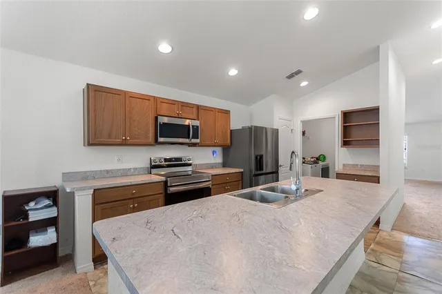 a kitchen with stainless steel appliances a refrigerator sink and microwave