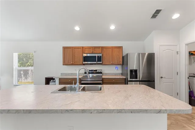 a kitchen with stainless steel appliances a refrigerator and a stove top oven
