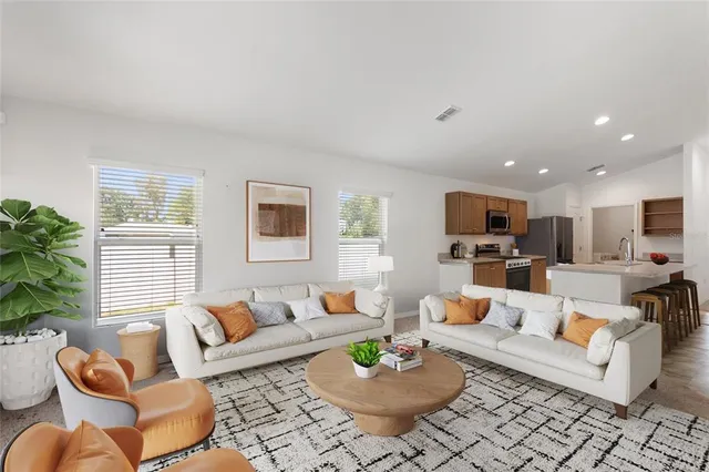 a living room with furniture kitchen view and a window