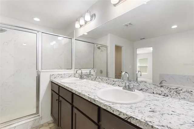 a bathroom with a granite countertop sink and a mirror