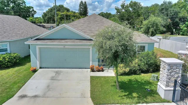 a front view of a house with a yard and trees
