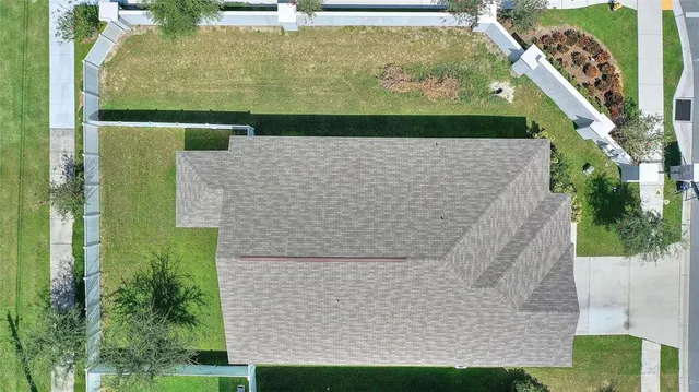 an aerial view of residential houses with outdoor space and lake view