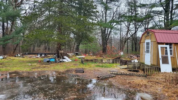 a view of swimming pool with lawn chairs and plants