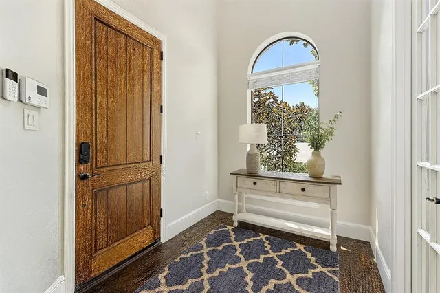 an empty room with wooden floor closet and windows