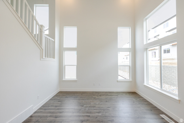 4741 Olive Avenue, Unit 406 Mapleton, UT 84664 - Photo 8 of 20 Empty room featuring a high ceiling and dark wood-type flooring