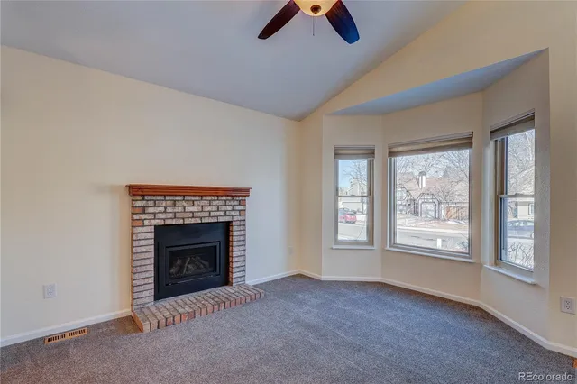 an empty room with fireplace and window