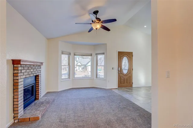 a view of an empty room with a fireplace and a window