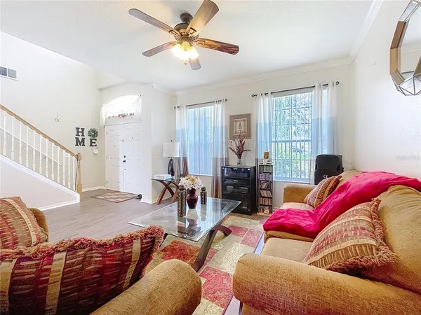an empty room with wooden floor and ceiling fan