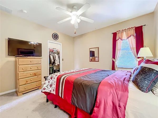 a spacious bedroom with a bed and dresser