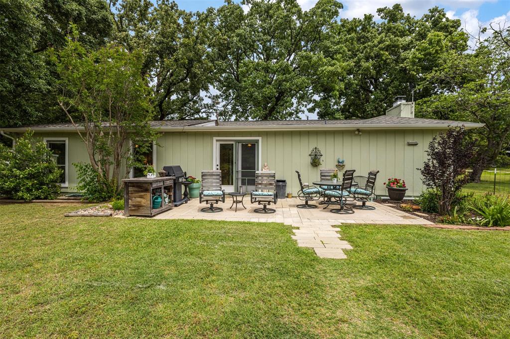 713 Midway Road Tool, TX 75143 - Photo 21 of 28 a view of a back yard of the house with table and chairs under an umbrella