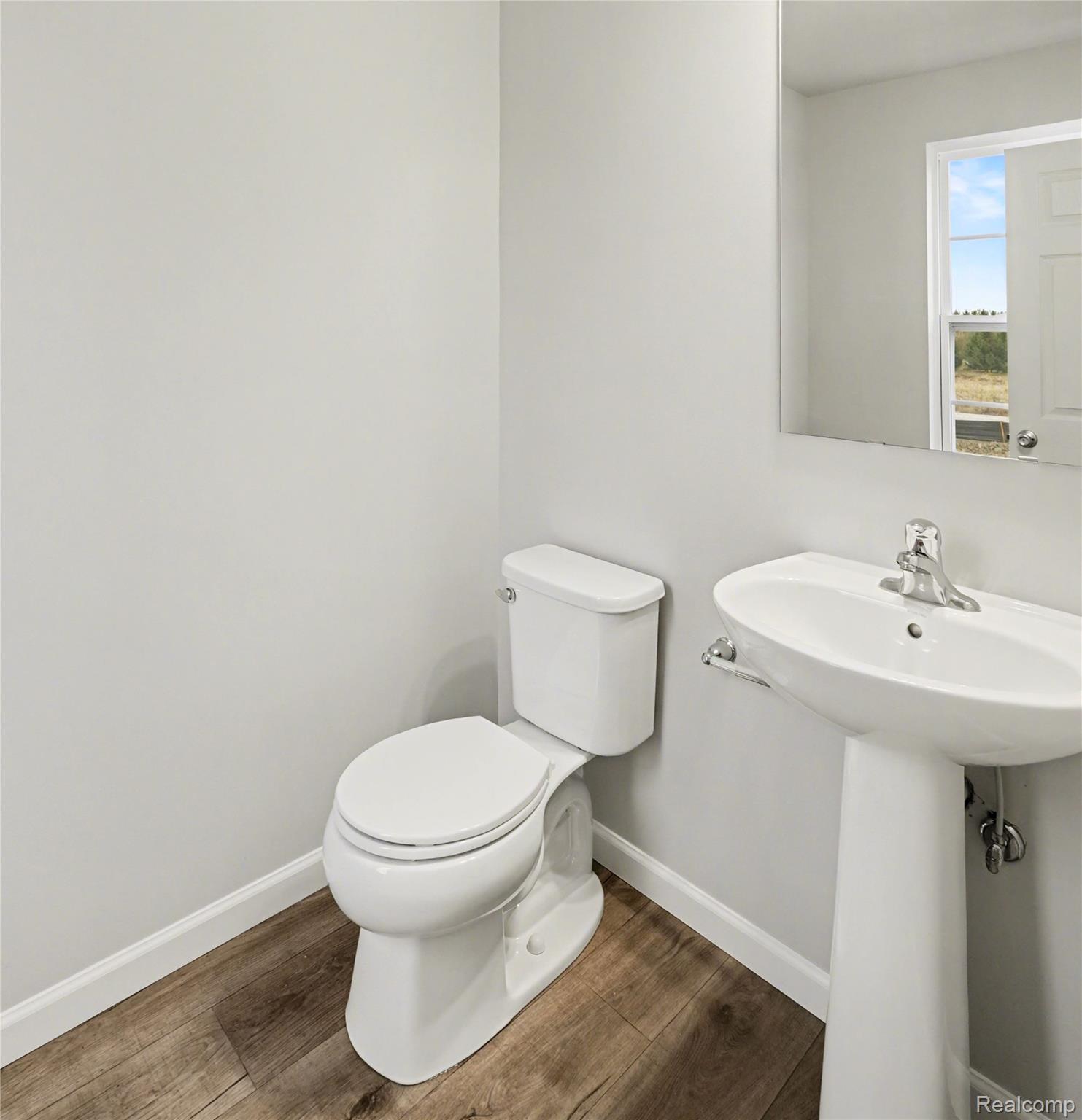 12521 Sharp Road Linden, MI 48451 - Photo 13 of 25 Powder room featuring a pedestal sink with chrome fixtures, a white toilet, wood-finish flooring, and light-toned wall paint