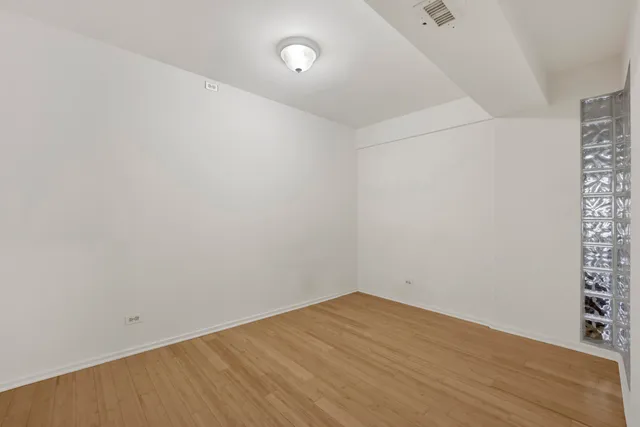 a view of empty room with wooden floor