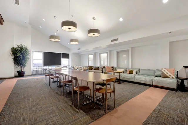 a living room with furniture a flat screen tv and a large window
