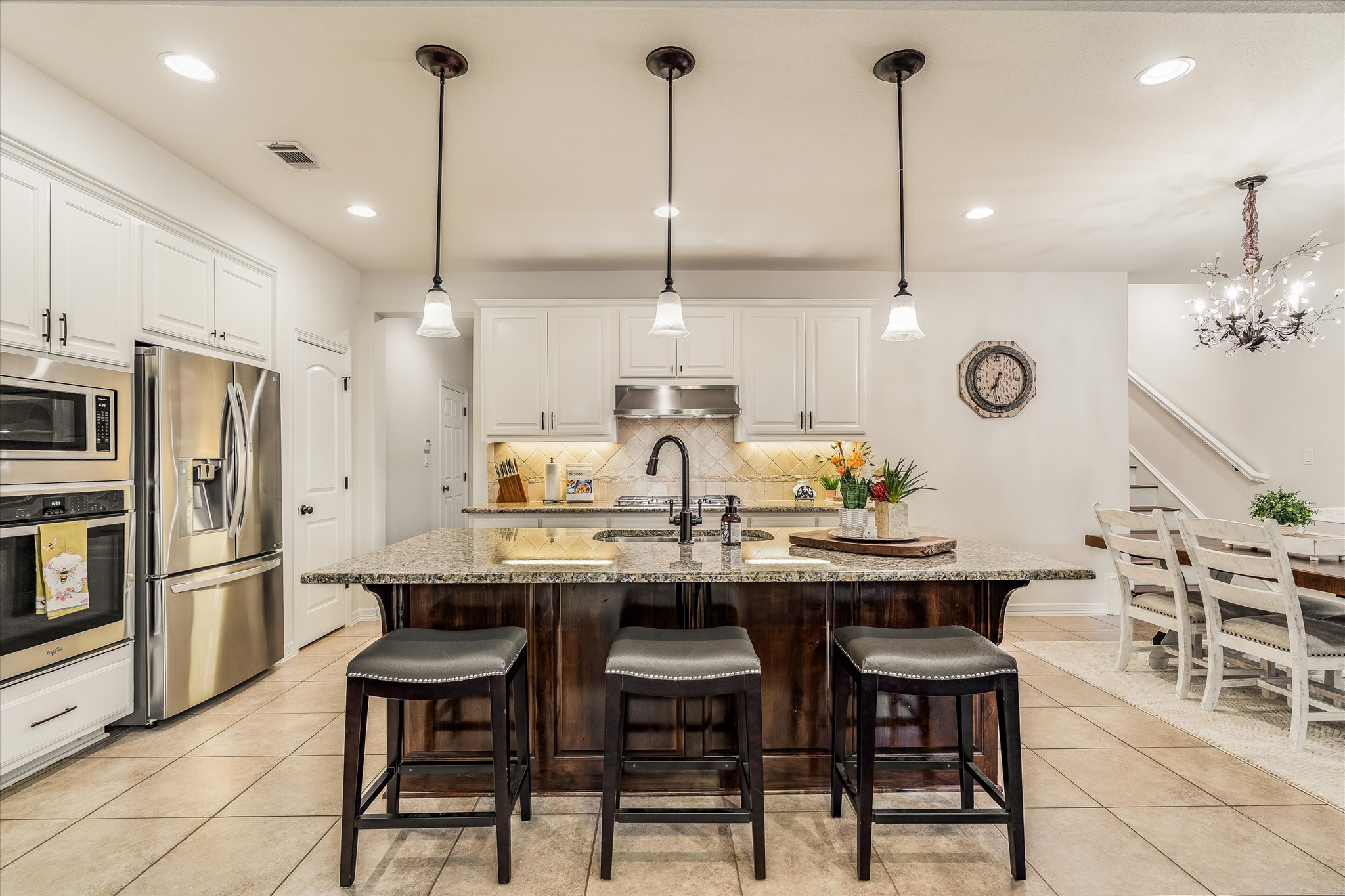 226 Galloway Lane Austin, TX 78737 - Photo 11 of 30 Dual tone kitchen featuring a breakfast bar, stainless steel appliances, light stone counters, dual tone cabinets, and light tile patterned flooring