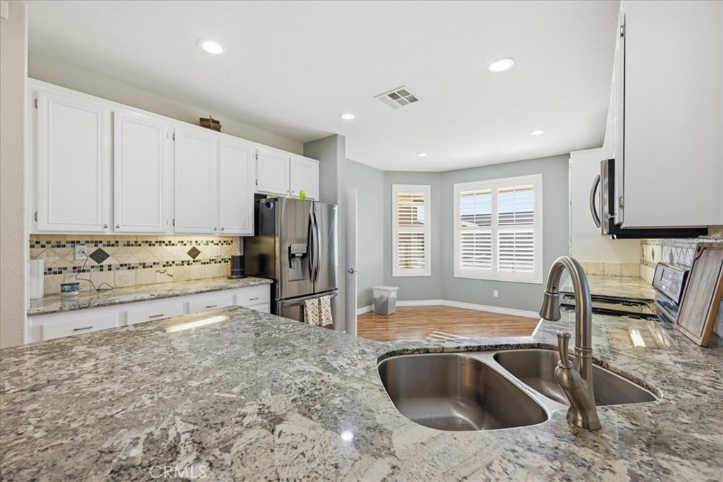 24884 Butterchurn Road Wildomar, CA 92595 - Photo 13 of 43 a kitchen with stainless steel appliances granite countertop a sink stove and refrigerator