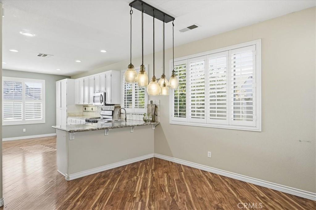 24884 Butterchurn Road Wildomar, CA 92595 - Photo 8 of 43 a kitchen with stainless steel appliances granite countertop a stove and a wooden floors