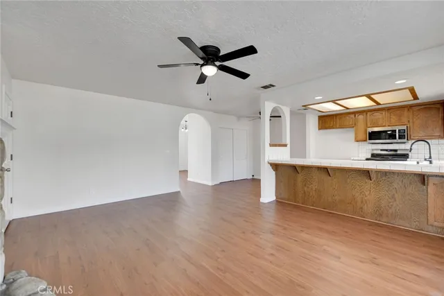 a view of kitchen with stainless steel appliances granite countertop a stove and a sink