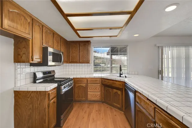 a kitchen with stainless steel appliances granite countertop sink stove microwave and cabinets