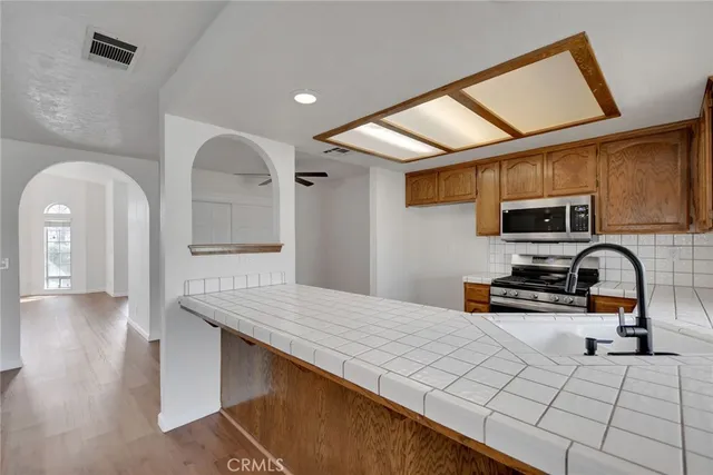 a kitchen with stainless steel appliances kitchen island granite countertop a stove a sink and a microwave