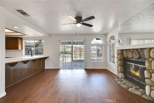 a view of an empty room with a kitchen and a wooden floor