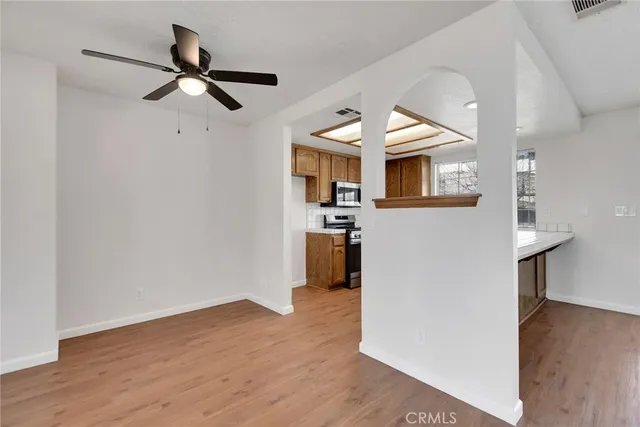 a view of a kitchen with a fridge wooden floor and a window