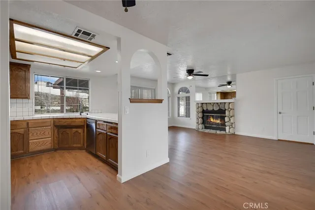 a kitchen with stainless steel appliances wooden floors and white cabinets