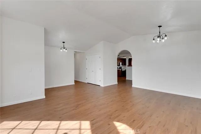 a view of empty room with wooden floor and window