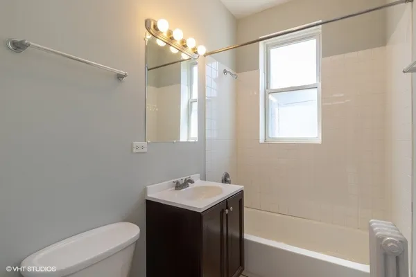 a bathroom with a sink vanity mirror and toilet