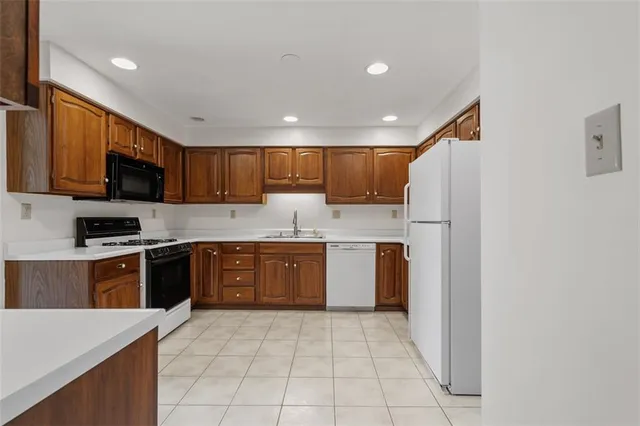 a large kitchen with stainless steel appliances granite countertop a refrigerator sink and cabinets