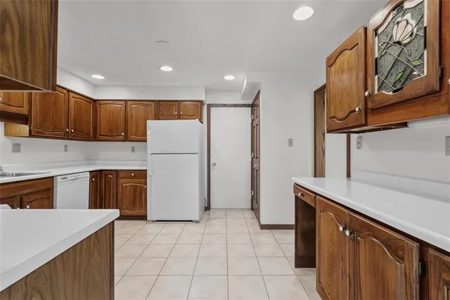 a kitchen with a refrigerator a stove top oven and cabinets