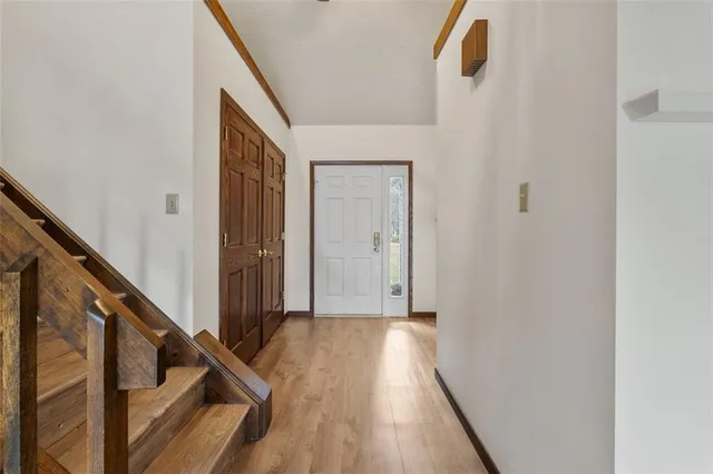 a view of a hallway with wooden floor and staircase