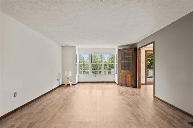 a view of a big room with wooden floor and windows in a room