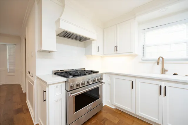 a kitchen with white cabinets and appliances
