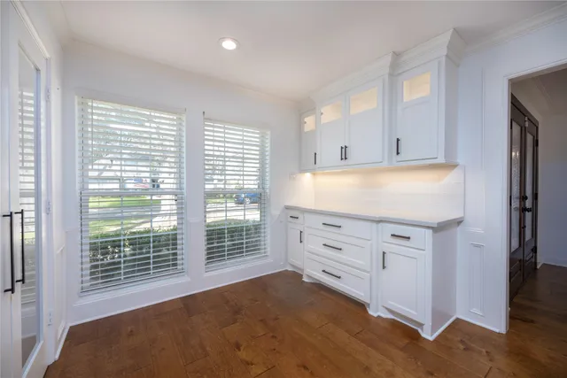 a kitchen with granite countertop white cabinets and window