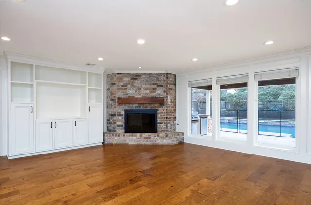 a view of an empty room with a fireplace and a window