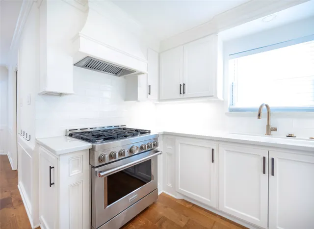 a kitchen with white cabinets and appliances