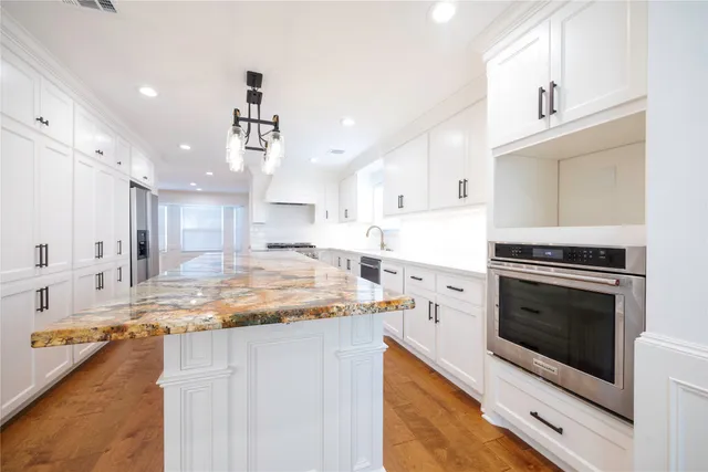 a kitchen with a stove sink and cabinets