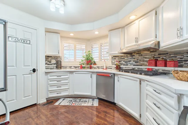 a view of kitchen with stainless steel appliances refrigerator stove and chair