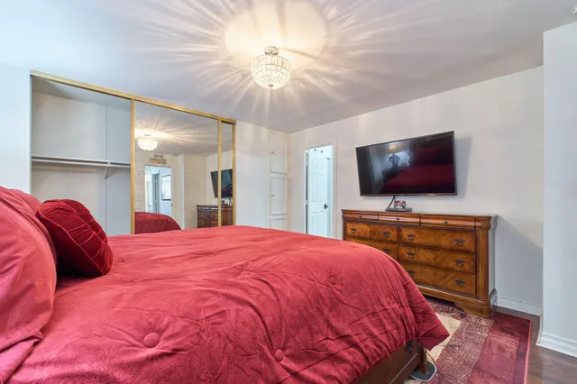 a bedroom with a bed a dresser and windows