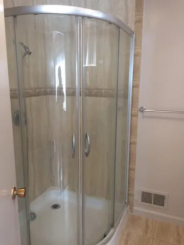 a bathroom with a granite countertop sink a toilet and shower