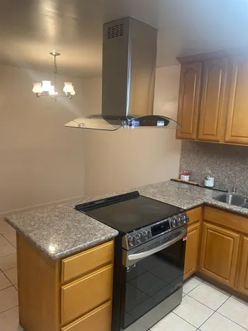 a kitchen that has a sink a stove and cabinets