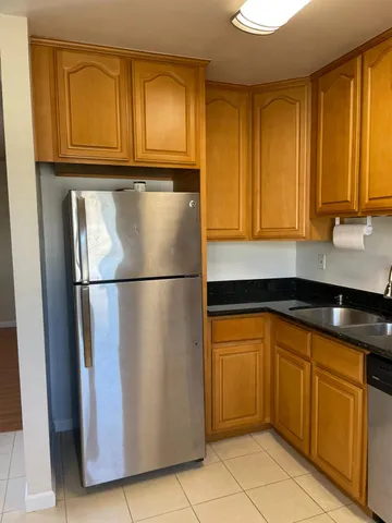 a kitchen with stainless steel appliances granite countertop a refrigerator stove and cabinets