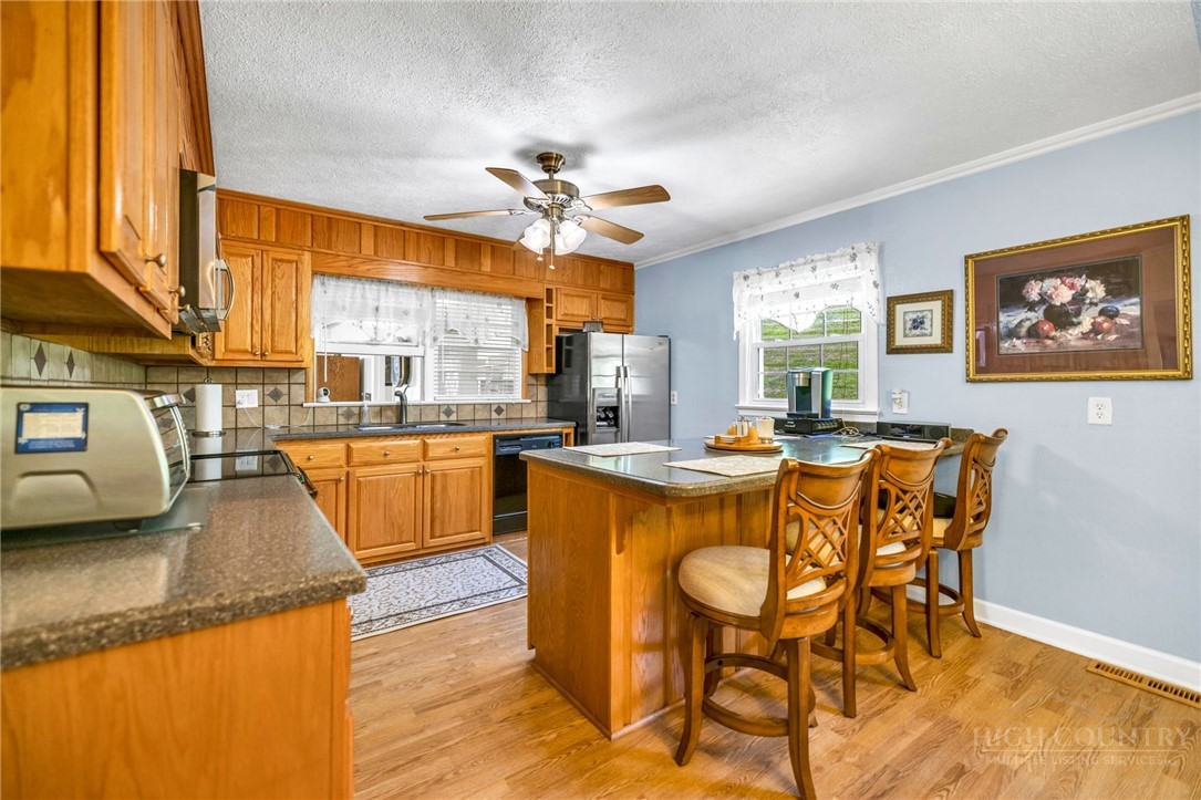 346 Piney Creek Road Lansing, NC 28643 - Photo 10 of 24 a dining hall with stainless steel appliances granite countertop a sink a counter space and a dining table
