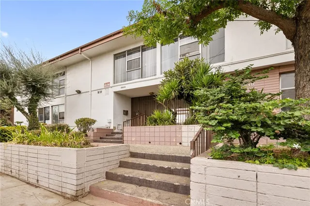 a front view of a house with plants