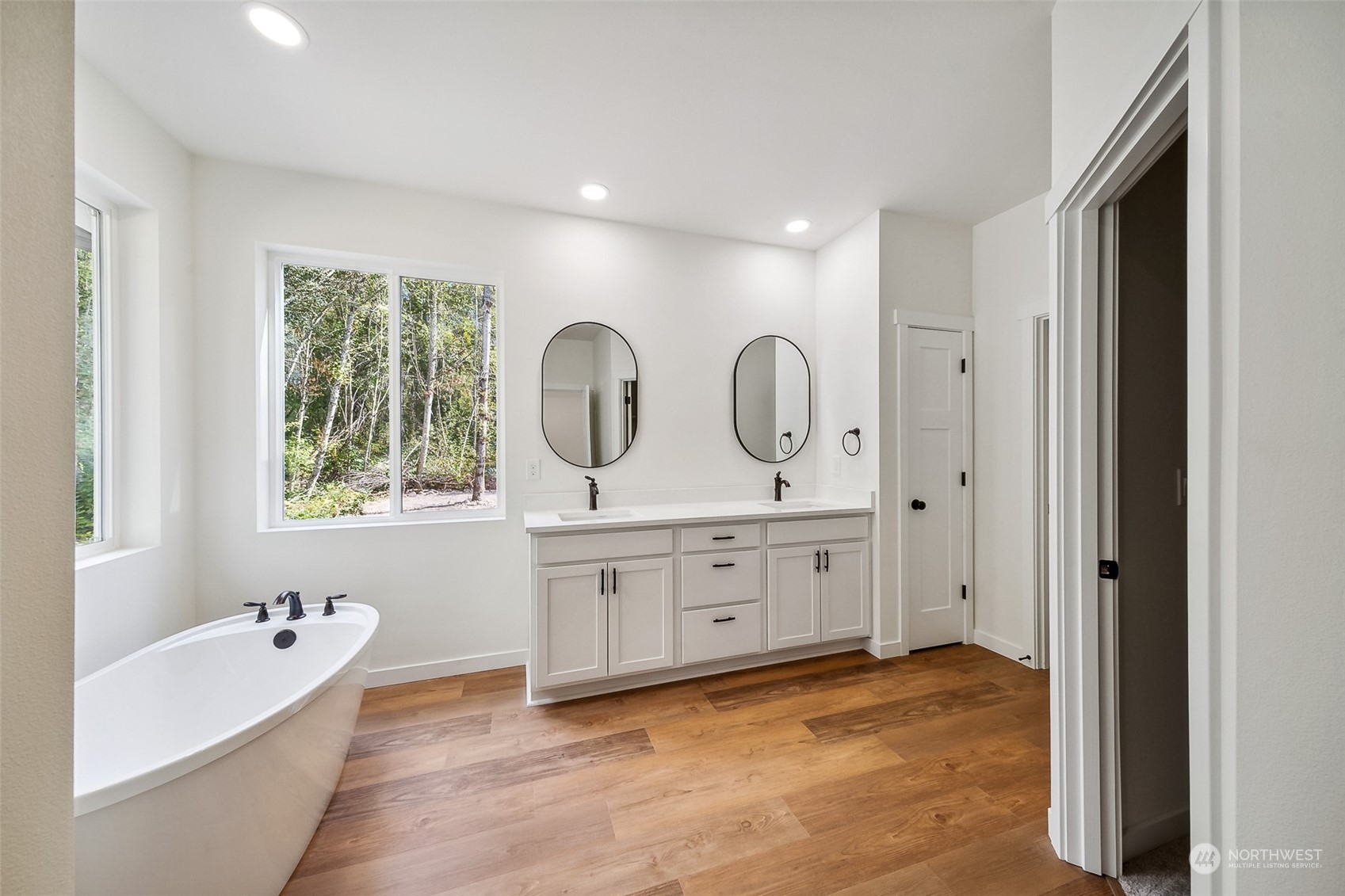 27117 Entwhistle Road East Buckley, WA 98321 - Photo 17 of 40 a spacious bathroom with double vanity a window a bathtub and mirrors