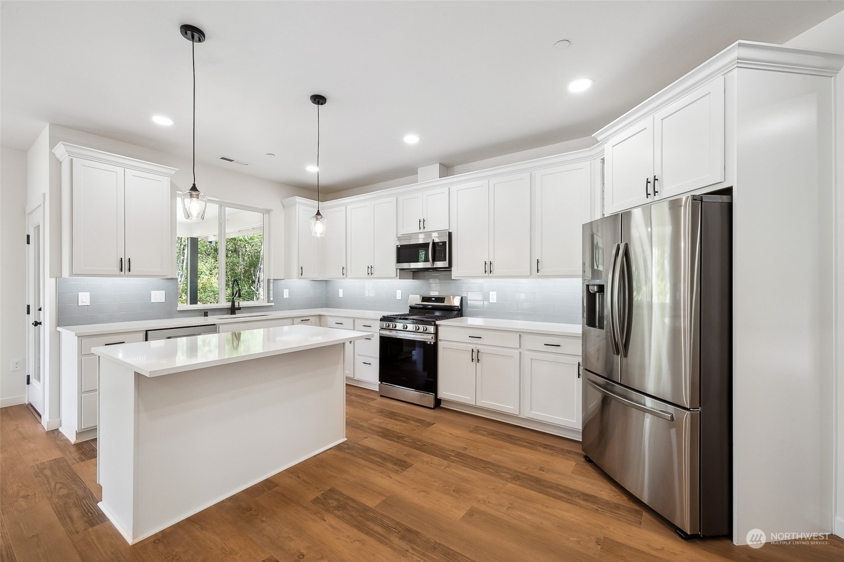 27117 Entwhistle Road East Buckley, WA 98321 - Photo 9 of 40 a kitchen with stainless steel appliances granite countertop a refrigerator a sink dishwasher a stove and white cabinets with wooden floor