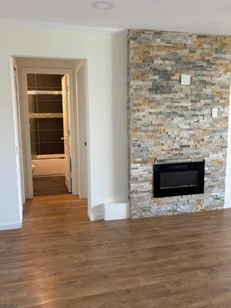 a view of empty room with wooden floor and fireplace